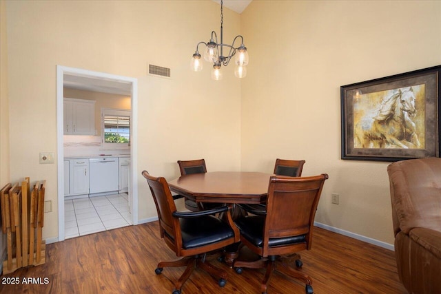 dining room with vaulted ceiling, light hardwood / wood-style floors, and a chandelier