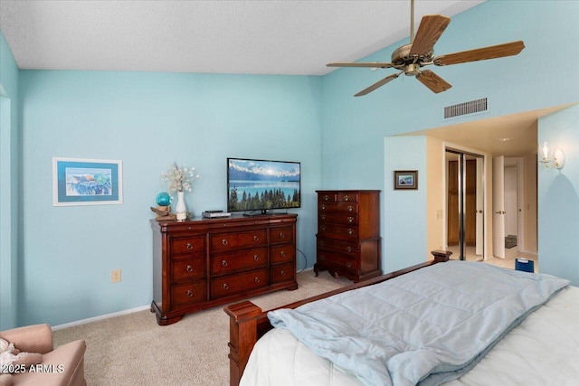 bedroom with lofted ceiling, ceiling fan, light colored carpet, and a textured ceiling