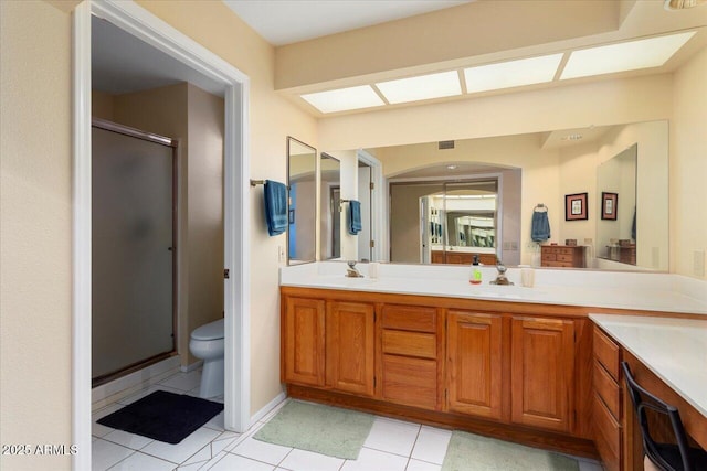 bathroom with vanity, a shower with door, tile patterned floors, and toilet