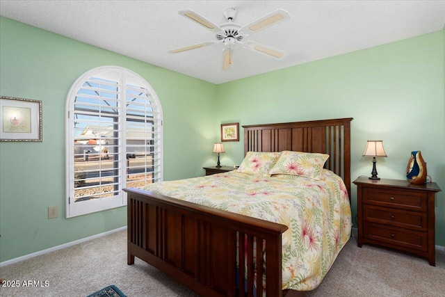 bedroom featuring multiple windows, light colored carpet, and a textured ceiling