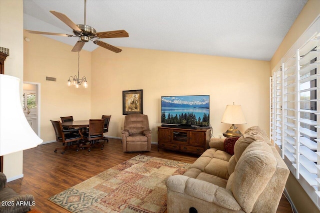 living room featuring dark hardwood / wood-style flooring, ceiling fan with notable chandelier, high vaulted ceiling, and a textured ceiling