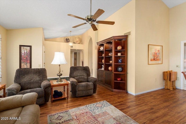 living room featuring dark wood-type flooring, ceiling fan, and high vaulted ceiling