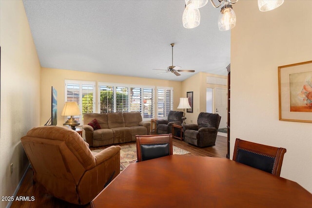 living room with ceiling fan, wood-type flooring, vaulted ceiling, and a textured ceiling