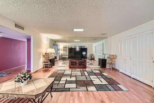 living room featuring light hardwood / wood-style flooring and a textured ceiling