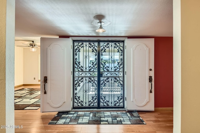 entryway with light wood-type flooring and a textured ceiling