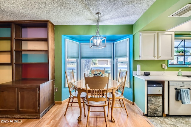 dining space with light hardwood / wood-style floors and a chandelier