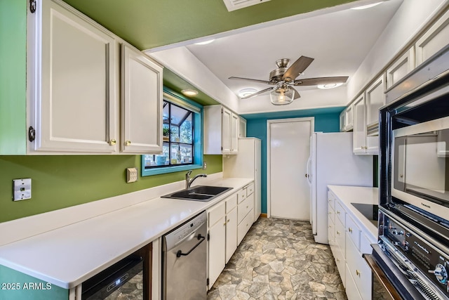 kitchen with white cabinets, appliances with stainless steel finishes, ceiling fan, and sink