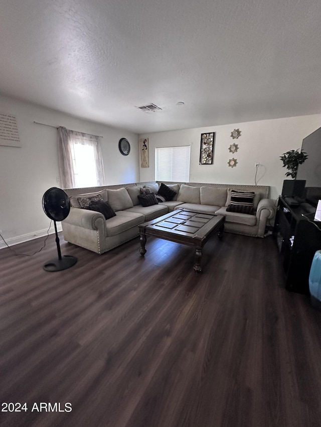 living room with a textured ceiling and dark hardwood / wood-style flooring