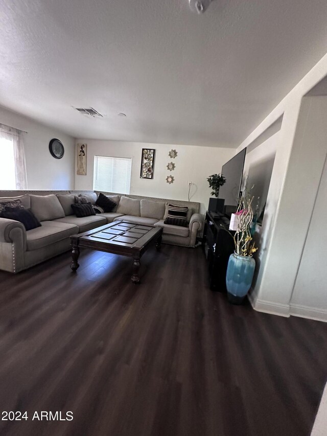 living room featuring a textured ceiling and dark hardwood / wood-style floors