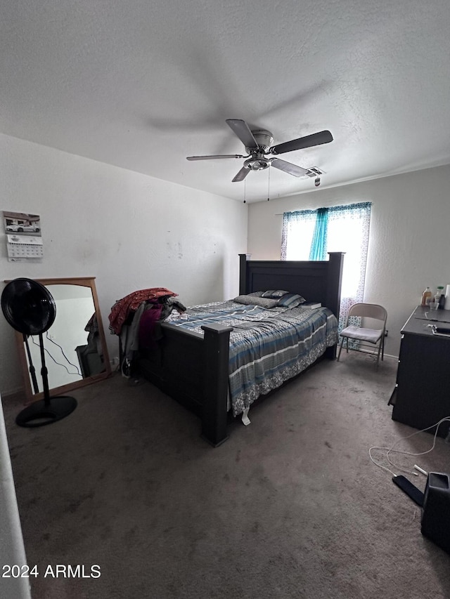 carpeted bedroom with ceiling fan and a textured ceiling