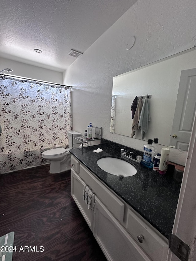 bathroom featuring toilet, a textured ceiling, hardwood / wood-style floors, and vanity