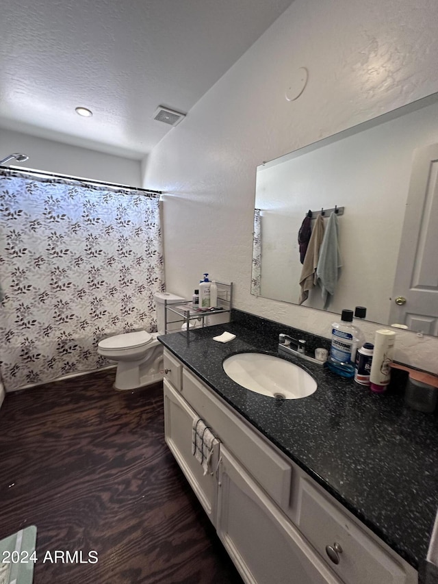 bathroom featuring toilet, a shower with shower curtain, hardwood / wood-style floors, and vanity