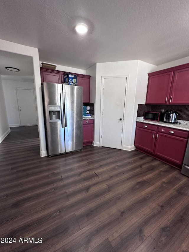 kitchen featuring backsplash, stainless steel fridge, dark hardwood / wood-style flooring, and a textured ceiling