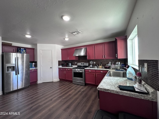 kitchen with sink, appliances with stainless steel finishes, wall chimney exhaust hood, and tasteful backsplash