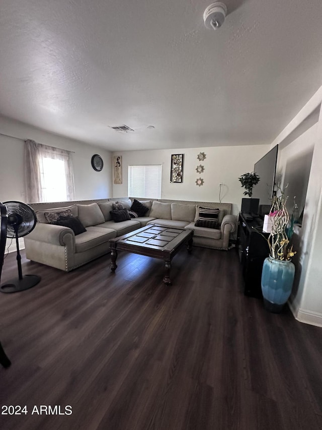 living room with dark hardwood / wood-style flooring and a textured ceiling