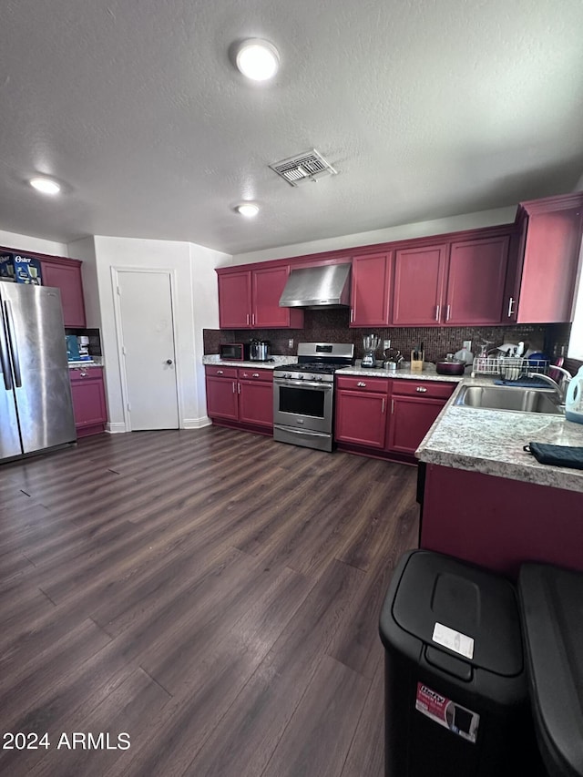 kitchen with stainless steel appliances, wall chimney exhaust hood, dark hardwood / wood-style floors, and sink