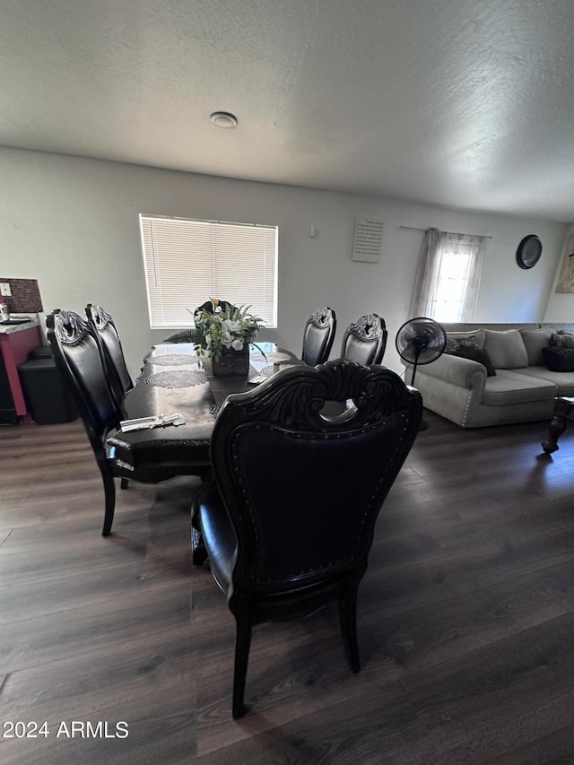 dining room featuring a textured ceiling and dark hardwood / wood-style flooring