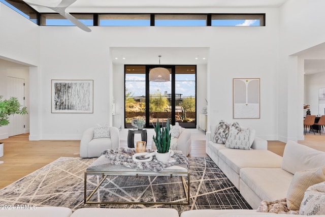 living room featuring a wealth of natural light, wood-type flooring, and a high ceiling