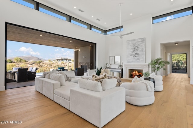 living room featuring a towering ceiling and light hardwood / wood-style flooring