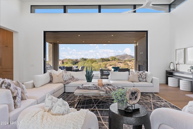 living room with plenty of natural light, a towering ceiling, and hardwood / wood-style flooring