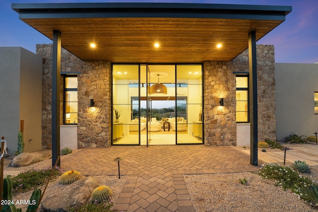 exterior entry at dusk with a patio area