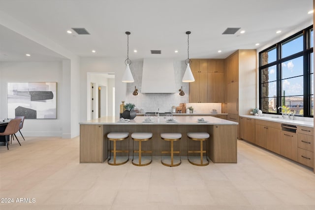 kitchen featuring a large island, a kitchen breakfast bar, tasteful backsplash, decorative light fixtures, and exhaust hood