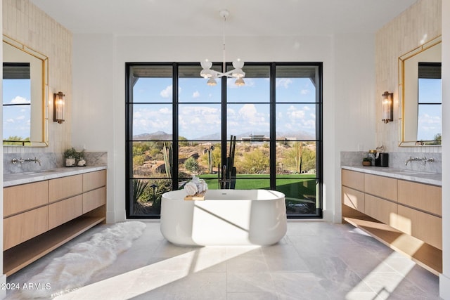9940 E Aleka Way, Scottsdale, AZ 85262 - bathroom with two vanities, a chandelier, a soaking tub, and plenty of natural light
