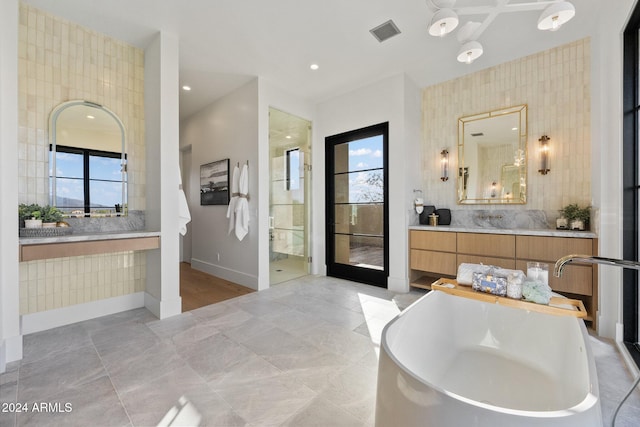 bathroom featuring plenty of natural light, vanity, and a washtub