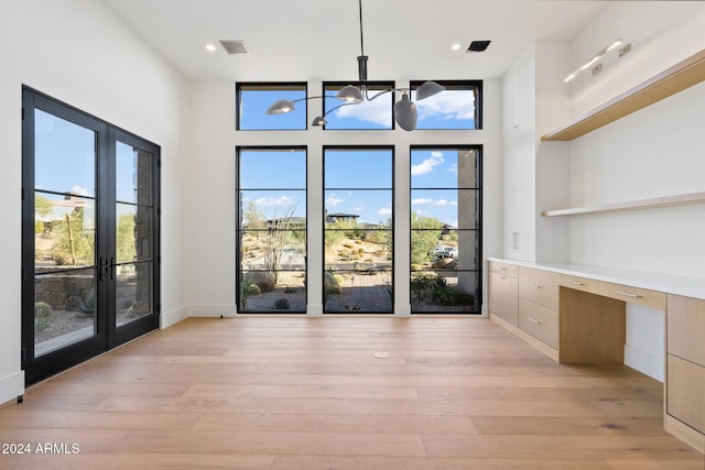 interior space featuring light hardwood / wood-style floors, built in desk, and a wealth of natural light