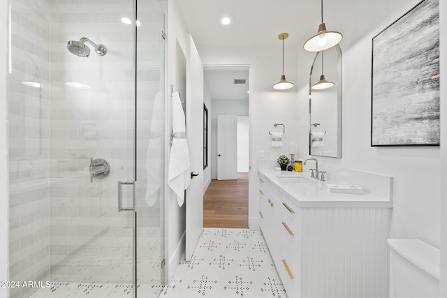 bathroom featuring hardwood / wood-style floors, vanity, and an enclosed shower