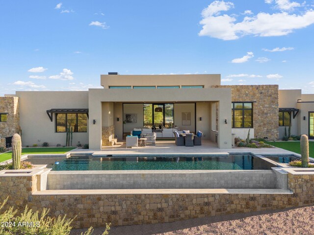 back of house with an outdoor living space and a patio