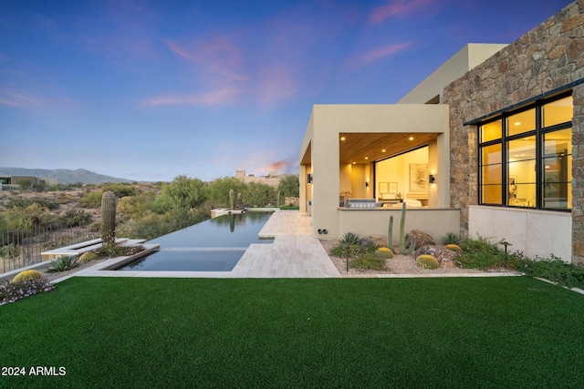 exterior space with a mountain view, an outdoor kitchen, and a patio area