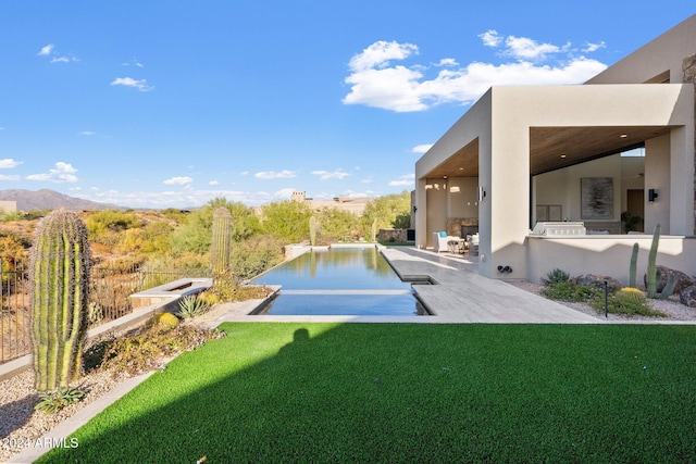 view of swimming pool featuring a lawn, a patio, and a water and mountain view