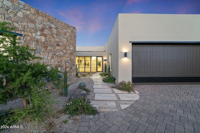 exterior entry at dusk with a garage