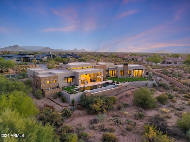 9940 E Aleka Way, Scottsdale, AZ 85262 - back of house at dusk featuring stucco siding, a mountain view, a residential view, and a patio area