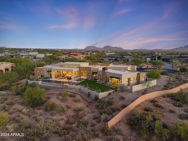 9940 E Aleka Way, Scottsdale, AZ 85262 - back of house at dusk featuring a mountain view, a residential view, stucco siding, and a patio area