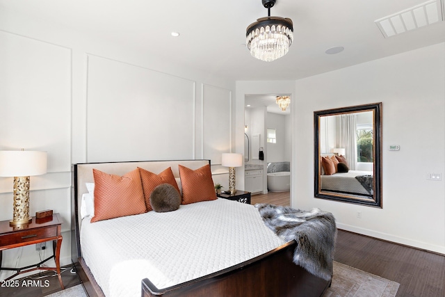 bedroom with a chandelier, recessed lighting, wood finished floors, visible vents, and baseboards