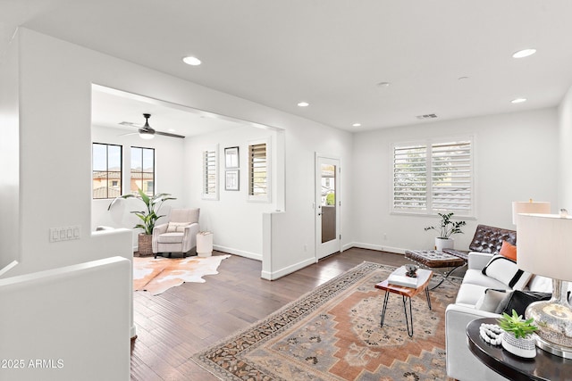 living room with recessed lighting, visible vents, baseboards, and wood finished floors