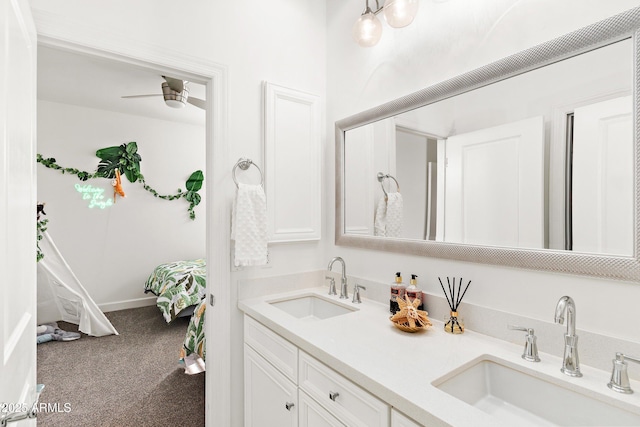 full bathroom with double vanity, a ceiling fan, baseboards, and a sink