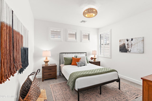 bedroom featuring baseboards, visible vents, and light colored carpet