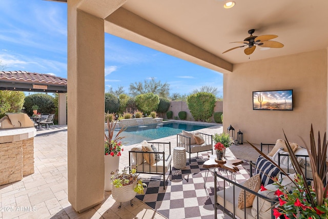 view of pool featuring a patio, an outdoor kitchen, a fenced in pool, and a ceiling fan