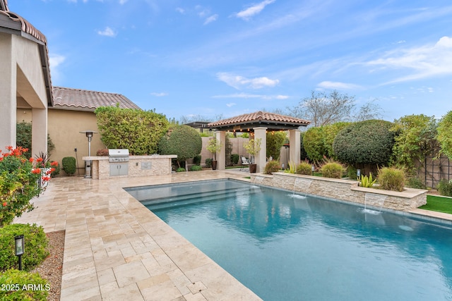 view of swimming pool featuring a patio, an outdoor kitchen, area for grilling, a gazebo, and a fenced in pool