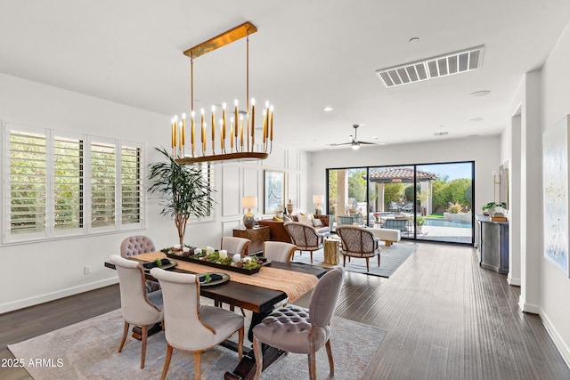 dining room featuring visible vents, dark wood finished floors, a notable chandelier, and baseboards