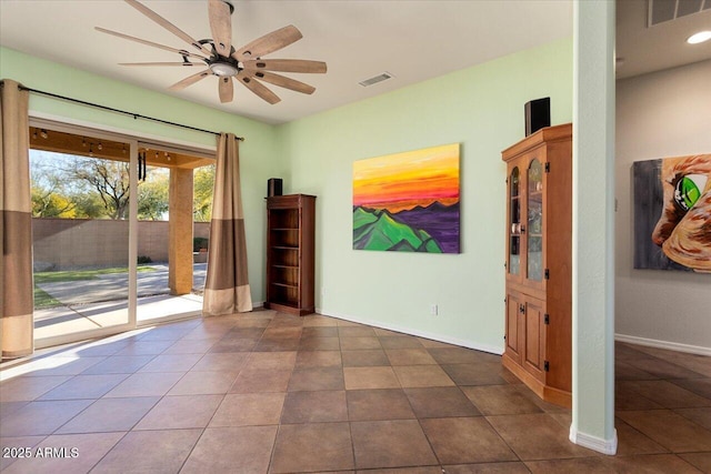 unfurnished room with ceiling fan and dark tile patterned floors