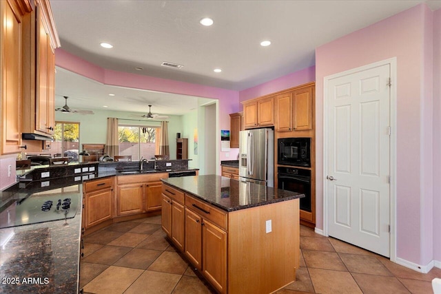 kitchen featuring sink, a center island, dark stone countertops, kitchen peninsula, and black appliances