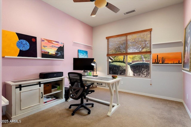 carpeted home office featuring ceiling fan