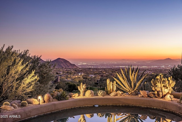 pool at dusk featuring a mountain view