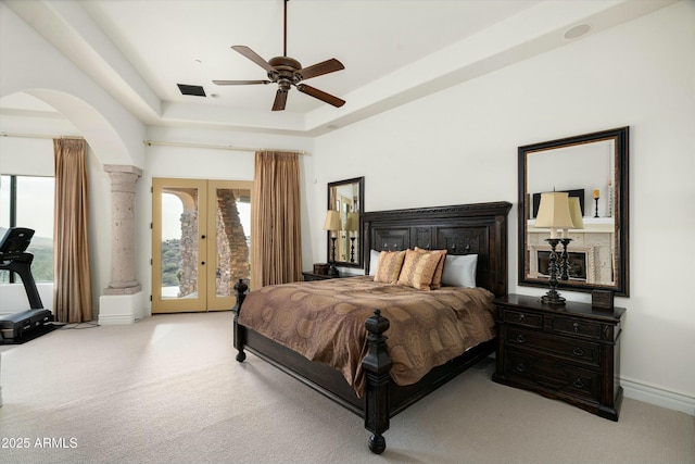 bedroom featuring light carpet, ceiling fan, a raised ceiling, access to outside, and french doors