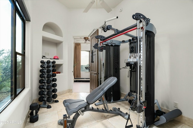 workout room with ceiling fan, light tile patterned floors, and built in shelves