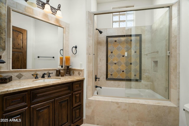 full bathroom with decorative backsplash, tiled shower / bath combo, vanity, and toilet